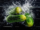 Fresh Green Cucumbers Splashing Into Water in Dynamic Close-Up