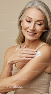 Elegant Elderly Woman Smiling While Applying Skin Lotion for Mature Skin