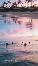 Surfers Waiting Calmly in Ocean at Sunset