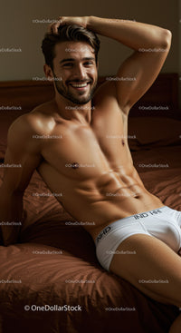 Smiling muscular man relaxing on brown bed sheets