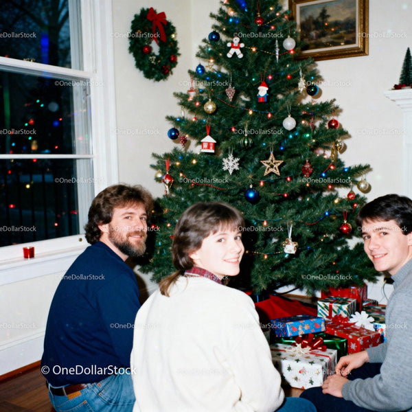 Family gathering for Christmas around decorated tree