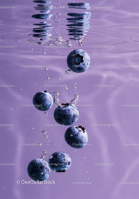 Fresh blueberries submerged in clear water with bubbles