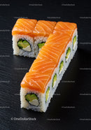 Fresh salmon avocado sushi rolls on black surface