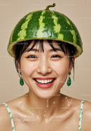 Smiling woman wearing watermelon helmet with water drops