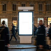 Bright illuminated city billboard surrounded by pedestrians