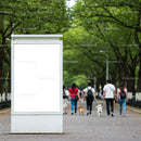 Empty white billboard in green park walkway with people