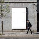 Man walking past blank outdoor billboard on urban street