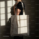 Woman carrying blank beige canvas tote bag in soft light