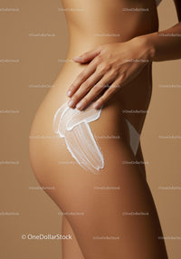 Beautiful woman applying moisturizer to her thigh with smooth skin