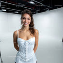 Happy Young Woman in White Dress Smiling in Studio