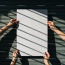 Hands holding blank white paper with shadows on metal background