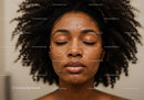 Elegant Black Woman with Afro Hair and Clay Facial Mask for Skin Rejuvenation