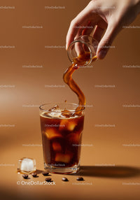 Pouring Cold Brew Coffee with Ice Cubes and Coffee Beans