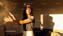Young woman clapping hands with flour in warm light