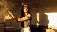 Young woman clapping hands with flour in warm light