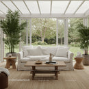 Cozy sunroom with white sofa and lush garden view