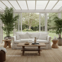 Cozy sunroom with white sofa and lush garden view