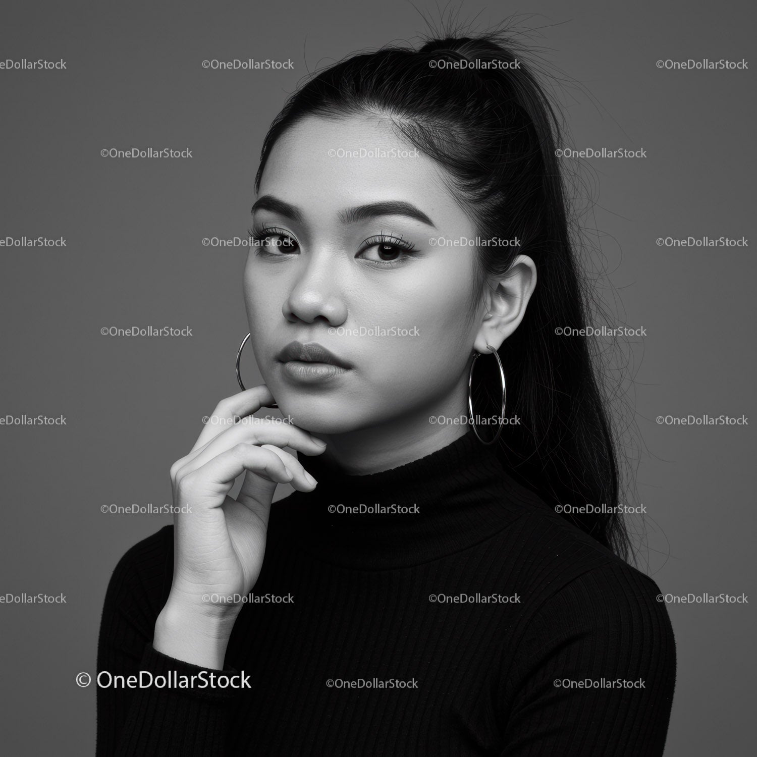 Elegancki czarno-biały portret młodej kobiety z kolczykami w kształcie kółek
