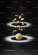 Almonds falling on white powder around hazelnut ball