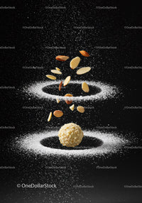 Almonds falling on white powder around hazelnut ball