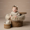 Smiling baby girl sitting in cozy woven basket