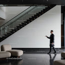 Blurred man walking past modern staircase in lobby