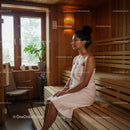 Relaxing Woman Sitting in Sauna Room with Wooden Interior and Towels