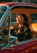 Elegant Woman Sitting in Vintage Car with Sunset Lighting