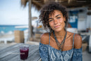 Young Woman Smiling at Beachside Café During Summer Vacation