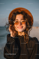 Happy Woman Wearing Straw Hat and Sunglasses on Sunset Beach