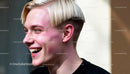 Young man laughing with trendy blonde bowl haircut