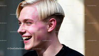 Young man laughing with trendy blonde bowl haircut