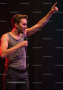 Young man passionately speaking on stage with microphone