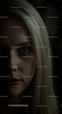 Close up portrait of woman with blue eyes in low light
