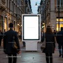 Blank illuminated billboard on busy urban street at dusk