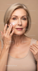 Elegant Mature Woman Applying Face Cream for Youthful Skin