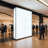 Busy shopping mall corridor with blank advertising board