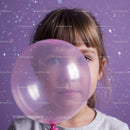 Young girl peeking through translucent pink balloon