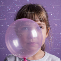 Young girl peeking through translucent pink balloon
