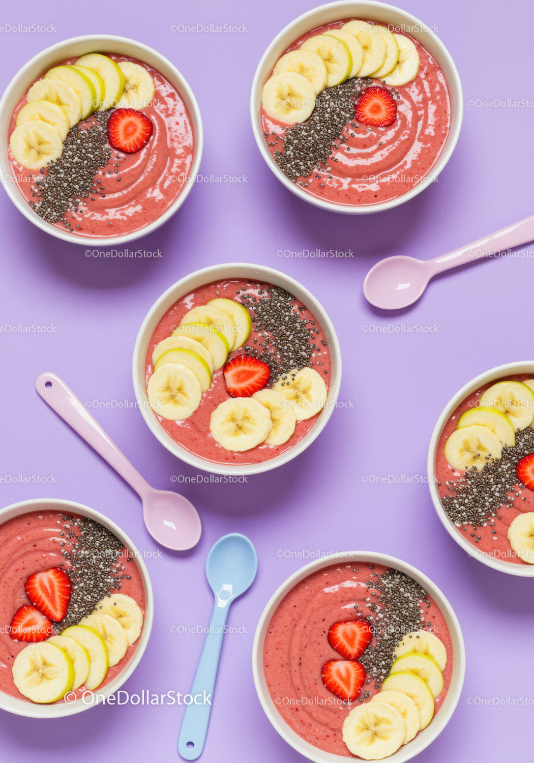 Kolorowe miski z jagodowym smoothie i świeżymi owocowymi dodatkami