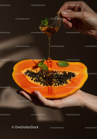 Honey drizzling over fresh ripe papaya slice