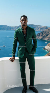 Young man in green suit standing by the sea cliff
