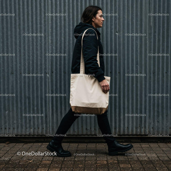 Man walking with canvas tote bag on urban street JPG Mockup Image