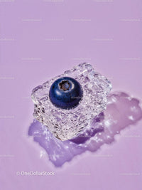 Single blueberry frozen inside melting ice cube