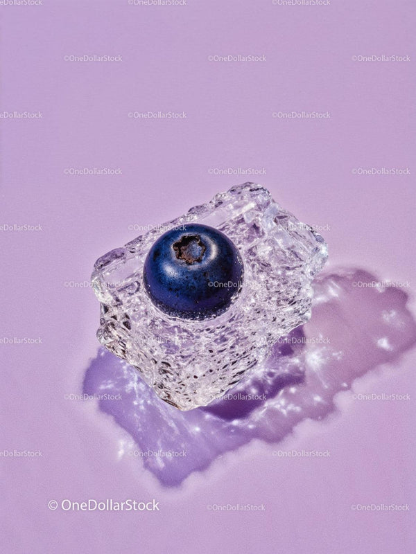 Single blueberry frozen inside melting ice cube