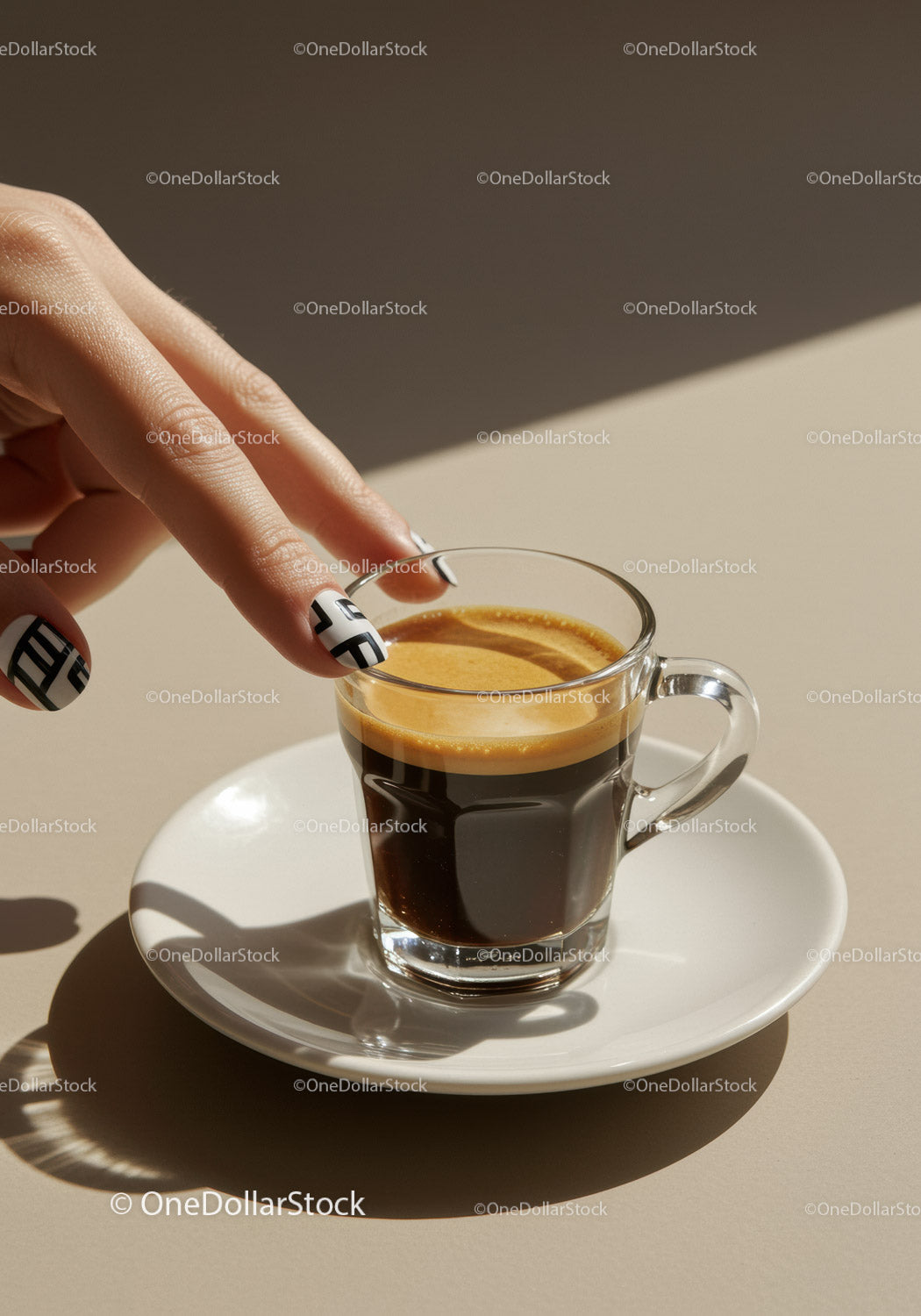 Palce dotykające świeżego espresso w przezroczystej szklanej filiżance