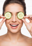 Cheerful Woman with Cucumber Slices Over Her Eyes for Fresh Skin