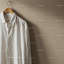Classic white shirt hanging on wooden hanger indoors