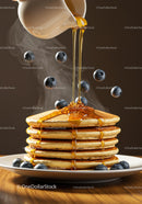 Stack of pancakes with blueberries and honey drizzle