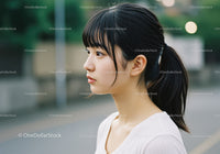 Young Woman in Profile Outdoors with Black Ponytail and Casual Attire